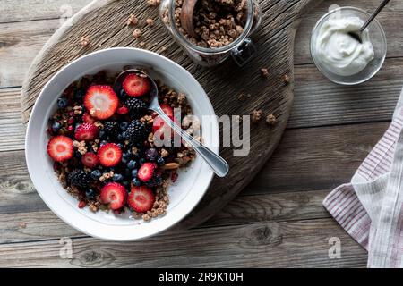 Eine gesunde Frühstückschüssel mit Granola Clustern und Beeren, bereit zum Essen. Stockfoto