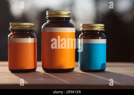 Gruppe von Arzneimittelbehältern auf dem Tisch, natürliches Licht. Modell, leeres Etikett. Stockfoto