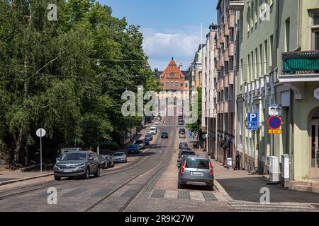 Blick auf die Straße von Snellmaninkatu mit geparkten Autos und Straßenbahnschienen an einem sonnigen Sommertag im Stadtteil Kruununhaka in Helsinki, Finnland Stockfoto