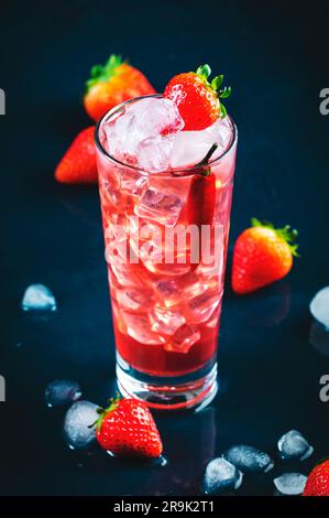 Rotes alkoholisches Cocktailgetränk mit Wodka, Grapefruitsaft, Erdbeeren, Zucker und heißem Chili-Pfeffer. Highball-Glas auf dunkelblauem Hintergrund Stockfoto