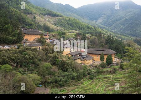 Ein Luftblick auf Tulou Cluster umgeben von üppigem Grün. Provinz Fujian, China. Stockfoto