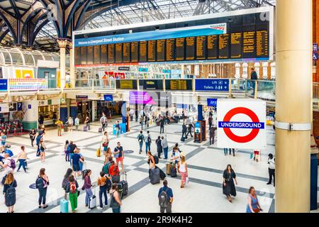 Großer elektronischer Abflugbildschirm an der Liverpool Street Station in London, Großbritannien. Der Bahnhof ist voll mit Passagieren, die von einer hohen Höhe aus gesehen werden. Stockfoto