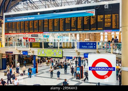 Großer elektronischer Abflugbildschirm an der Liverpool Street Station in London, Großbritannien. Der Bahnhof ist voll mit Passagieren. Stockfoto