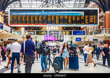 Großer elektronischer Abflugbildschirm an der Liverpool Street Station in London, Großbritannien. Der Bahnhof ist voll mit Passagieren. Stockfoto