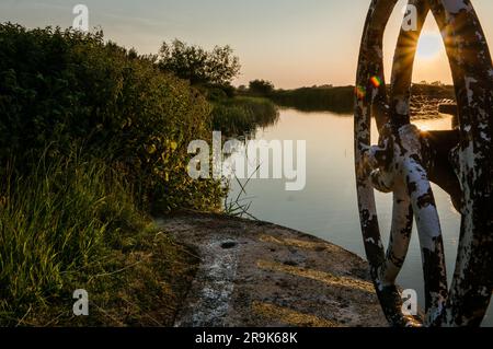Sonnenuntergang hinter einem Riesenrad am Fluss in Kent, Großbritannien Stockfoto
