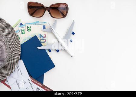 Draufsicht auf Reisezubehör, Hut, Brille, Kamera, Reisepässe und Flugtickets im Hintergrund mit Kopierbereich für Text. Reiseurlaubskonzept Stockfoto