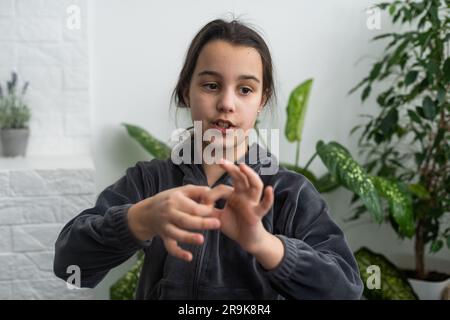Wunderschönes, lächelndes, taubes Mädchen, das Gebärdensprache benutzt. Stockfoto