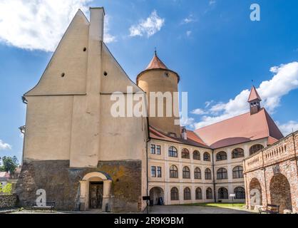 Luftaufnahme der Burg Veveri in Mähren mit großen Innenhöfen, mehreren Toren, quadratischen und runden Türmen mit wolkenblauem Himmel Stockfoto