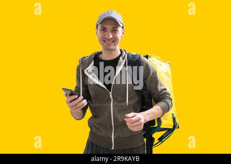 Liefermann mit Thermal-Rucksack für Essen. Essenslieferung zum Mitnehmen. Mann liefert online Lebensmittelbestellungen an Kunden mit Thermosack, Lebensmittellieferung. Stockfoto