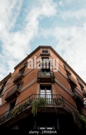 Ein Gebäude mit einer Pflanzmaschine im oberen Fenster und Eisengeländern darauf Stockfoto