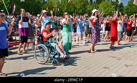 Junge Menschen tanzen zu christlichen Liedern während des Mladifests 2022 – dem Jugendfestival – in Medjugorje. Unter ihnen eine Frau im Rollstuhl. Stockfoto