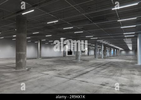 Abstraktes leeres Parkhaus mit Betonsäulen und Neonlichtern, Hintergrundfoto moderner Architektur Stockfoto