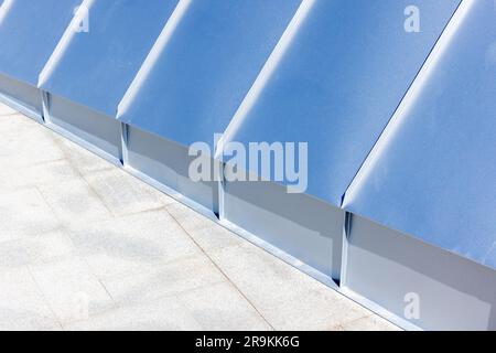 Hintergrundfoto abstrakter Architektur mit neuem glänzendem Dach aus Edelstahlplatten und Bodenfliesen aus Stein Stockfoto