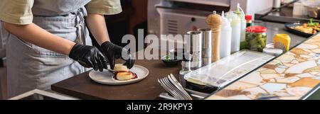 Nahaufnahme des Küchenchefs dekorieren Sie Käsekuchen, bevor Sie zum Frühstück in der Restaurantküche servieren Stockfoto