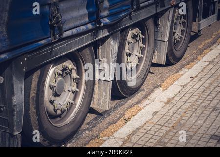 Ein alter blauer und grauer Lkw ist mit drei Reifen an der Seite abgebildet Stockfoto