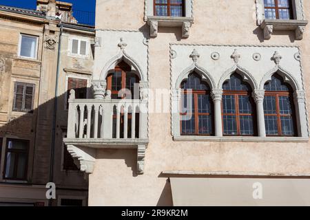 Piran, Slowenien - 14. Januar 2023: Das venezianische Haus mit gotischer Architektur aus der Mitte des 15. Jahrhunderts verfügt über ein Fenster mit dreifacher Lanzette und eine Ecke Stockfoto