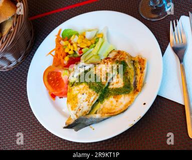 Gebratene dorada mit Pesto serviert mit Gemüsegarnierung Stockfoto