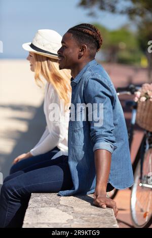 Nur ein verheiratetes Paar, das sich am Strand umarmt Stockfoto