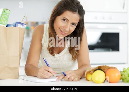Eine Frau, die die Einkaufsliste überprüft Stockfoto