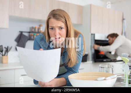 Eine Frau, die einen Brief mit einem Ausdruck der Bestürzung ansieht Stockfoto