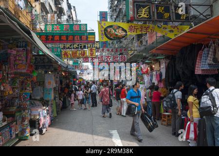 Hongkong, China - August 19. 2007: Viele Straßenverkäufer verkaufen Produkte auf der Straße zwischen den Gebäuden. Einkaufslustige gehen durch die geschäftigen Straßen von Mon Stockfoto