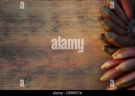 Leckere lila Bananen auf einem Holztisch, Blick von oben. Platz für Text Stockfoto