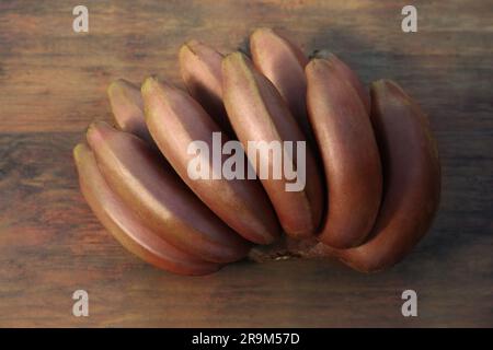 Leckere lila Bananen auf Holztisch, Nahaufnahme Stockfoto