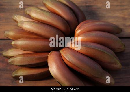 Leckere lila Bananen auf Holztisch, Nahaufnahme Stockfoto