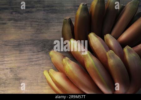 Leckere lila Bananen auf einem Holztisch, Blick von oben. Platz für Text Stockfoto