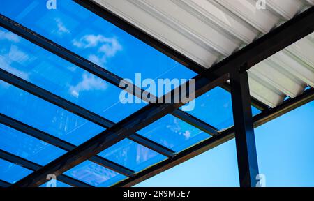 Pergola aus Aluminium für Außenterrasse vor klarem blauen Himmel. Ansicht von unten. Ein kleiner Winkel von einer Terasse Pergola im Hintergrund eines schönen klaren Himmels, Selec Stockfoto