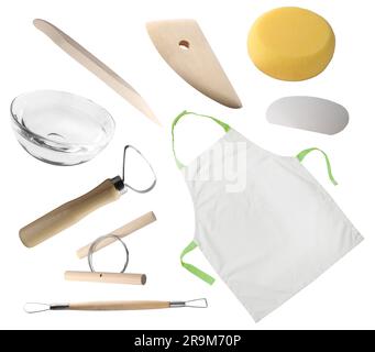 Set aus Keramikwerkzeugen, Schürze und Glasschale auf weißem Hintergrund Stockfoto