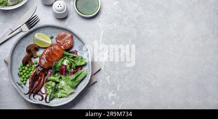 Leckerer gegrillter Tintenfisch auf grauem Tisch, flach liegend. Bannerdesign mit Platz für Text Stockfoto