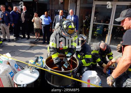 New York, USA, 27. Juni 2023, FDNY-Feuerwehr inspiziert eine E-Bike-Werkstatt in Manhattan Chinatown auf der Suche nach defekten und unsicheren Li-Ion-Batterien. Abbildung: Feuerwehrleute von NYC zerlegen eine Reihe Lithium-Ionen-Batterien und entsorgen sie in einem Behälter. Die jüngsten Todesfälle durch den Brand in einem E-Bike-Shop in der Madison Street im Juni 20. - zusätzlich zu mehreren anderen Bränden in diesem Jahr, die auf die Batterien von Elektrofahrrädern und defekte Ladegeräte in der ganzen Stadt zurückzuführen sind - haben die Stadt zu einer verstärkten Durchsetzung veranlasst. Stockfoto