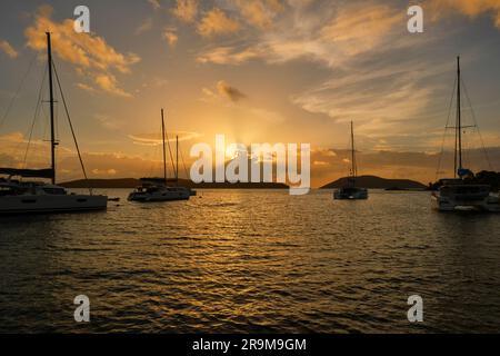 Katamaran-Segelboote liegen in Simpson Bay, St. Martin bei Sonnenuntergang, die Sonne verborgen hinter den Wolken. Stockfoto