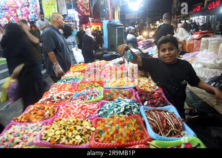 Gazastreifen, Gaza, 27. Juni 2023, Palästinenser kaufen Süßigkeiten auf einem populären Markt als Vorbereitung auf den bevorstehenden muslimischen Eid al-Adha-Urlaub in Rafah im südlichen Gazastreifen am Dienstag, den 27. Juni 2023. Moslems auf der ganzen Welt feiern Eid al-Adha (Opferfest), indem sie Schafe, Ziegen, Kühe und Kamele schlachten, um Prophet Abrahams Bereitschaft zu gedenken, seinen Sohn Ismail auf Gottes Befehl zu opfern. Foto: Ismael Mohamad/UPI Credit: UPI/Alamy Live News Stockfoto