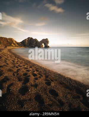 Eine ruhige Küstenlandschaft mit der berühmten Felsformation Durdle Door in Lulworth Cove, Dorset Stockfoto