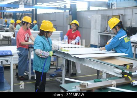 HAI'AN, CHINA - 28. JUNI 2023 - Arbeiter verarbeiten und verpacken Zubehör aus Aluminiumlegierungen für neue Energiefahrzeuge in einer Werkstatt in der Provinz Hai'an, Jiangsu Stockfoto