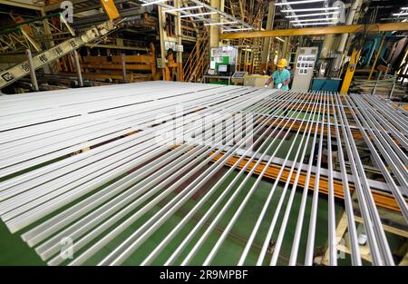 HAI'AN, CHINA - 28. JUNI 2023 - Arbeiter verarbeiten Aluminiumrahmen für Photovoltaik-Kraftwerke in einer Werkstatt in Hai'an, Provinz Jiangsu, China, Stockfoto