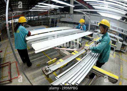 HAI'AN, CHINA - 28. JUNI 2023 - Arbeiter verarbeiten Aluminiumrahmen für Photovoltaik-Kraftwerke in einer Werkstatt in Hai'an, Provinz Jiangsu, China, Stockfoto