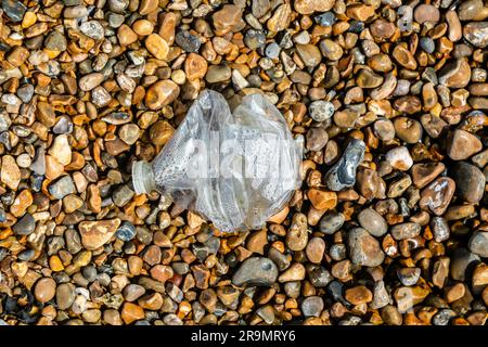 Zerdrückte Plastikflasche, angespült am Kieselstrand, Shingle Street, Suffolk, England, Großbritannien, Stockfoto