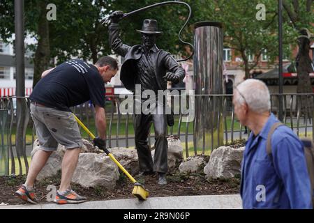 Eine lebensgroße Bronzestatue der Figur Indiana Jones, die gereinigt wird, während sie als neueste Ergänzung der Statue „Scenes in the Square“ auf dem Leicester Square enthüllt wird. Sie verewigt den Helden, den Harrison Ford mit seiner Peitsche und seinem Fedora aus dem Film „Jäger der verlorenen Arche“ von 1981 spielte. Bilddatum: Mittwoch, 28. Juni 2023. Stockfoto