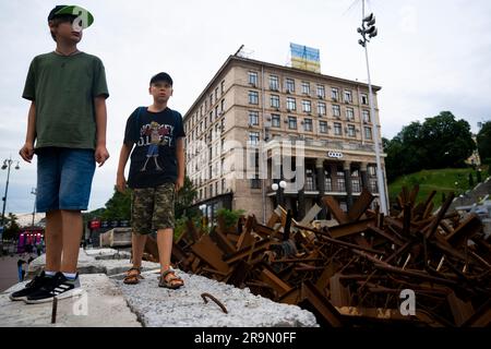 Kiew, Ukraine. 27. Juni 2023. Die Jungen gehen in der Nähe tschechischer Igel (Panzerabwehrhindernisse) am Maidan Nezalezhnosti (Unabhängigkeitsplatz) in Kiew, Ukraine, 27. Juni 2023. Kredit: Ondrej Deml/CTK Photo/Alamy Live News Stockfoto