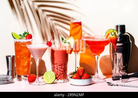 Erdbeercocktails-Set. Mocktails, Smoothies und Shakes mit Früchten und Beeren in Gläsern. Erfrischende kalte Getränke. Beige Pink Backgro Stockfoto
