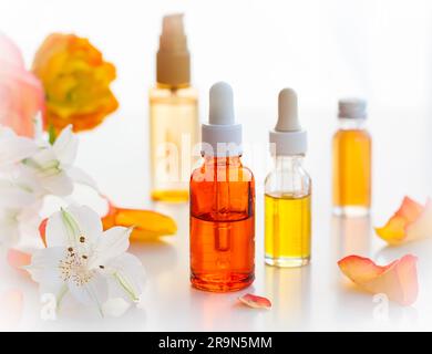 Flaschen mit ätherischen aromatischen Ölen und frischen Blumen Stockfoto