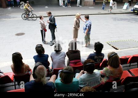 Die Schauspieler Allan V. Watt, Simon Laherty, Jim Russell und Genevieve Morris im Straßentheater „Small Metal Objects“, bei dem vier Schauspieler Mikrofon sind, während das Publikum den dialog über Kopfhörer hört, während er in einer belebten Straße der Stadt stattfindet. Das Sydney Festival, Circular Quay, Sydney, Australien. 08.01.07. Stockfoto