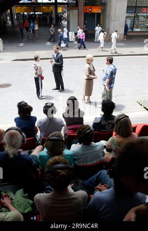 Die Schauspieler Allan V. Watt, Simon Laherty, Jim Russell und Genevieve Morris im Straßentheater „Small Metal Objects“, bei dem vier Schauspieler Mikrofon sind, während das Publikum den dialog über Kopfhörer hört, während er in einer belebten Straße der Stadt stattfindet. Das Sydney Festival, Circular Quay, Sydney, Australien. 08.01.07. Stockfoto