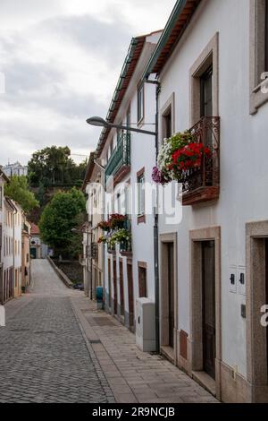 Straße einer kleinen Stadt in Portugal, wo Sie die typischen weißen Wände, Türen und Balkone sehen können Stockfoto