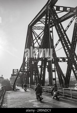 Motorradverkehr überquert die gemeinsame Straße und Eisenbahnbrücke, auch bekannt als Long Bien Bridge in der Dämmerung in Hanoi, Vietnam. Die Brücke stammt aus dem Jahr 1903 und W. Stockfoto