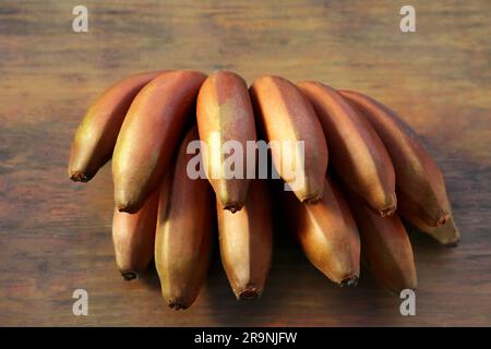 Leckere lila Bananen auf Holztisch, Nahaufnahme Stockfoto