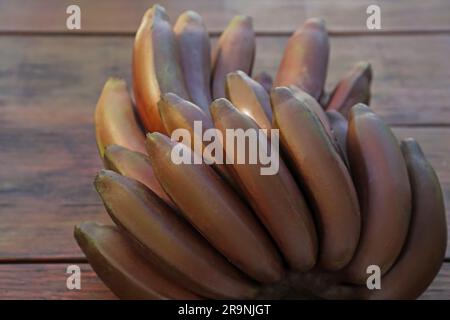 Leckere lila Bananen auf Holztisch, Nahaufnahme Stockfoto